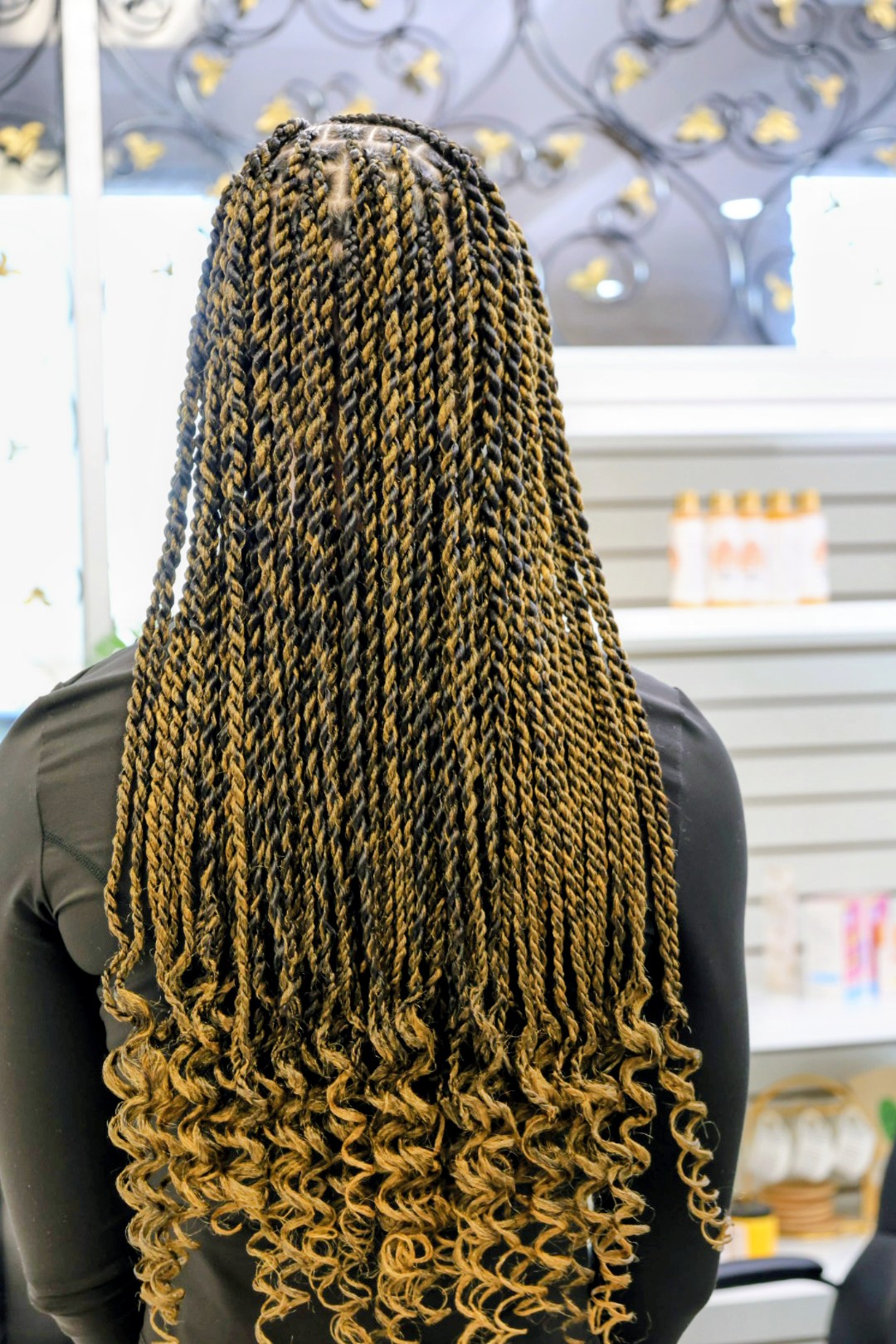 The back of a full head of honey-ombre Senegalese twists with loose spiral ends, at Jalia Walda Salon