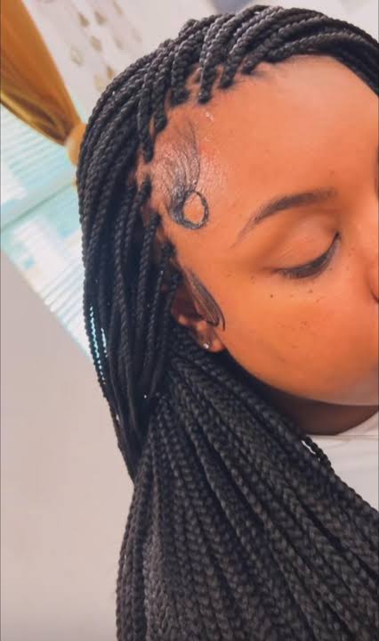 A close view of fine box braids at the hairline with the parting squares visible at the scalp
