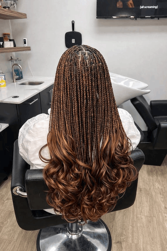 The back of a French curl install in copper brown, the curls gathered below the shoulders
