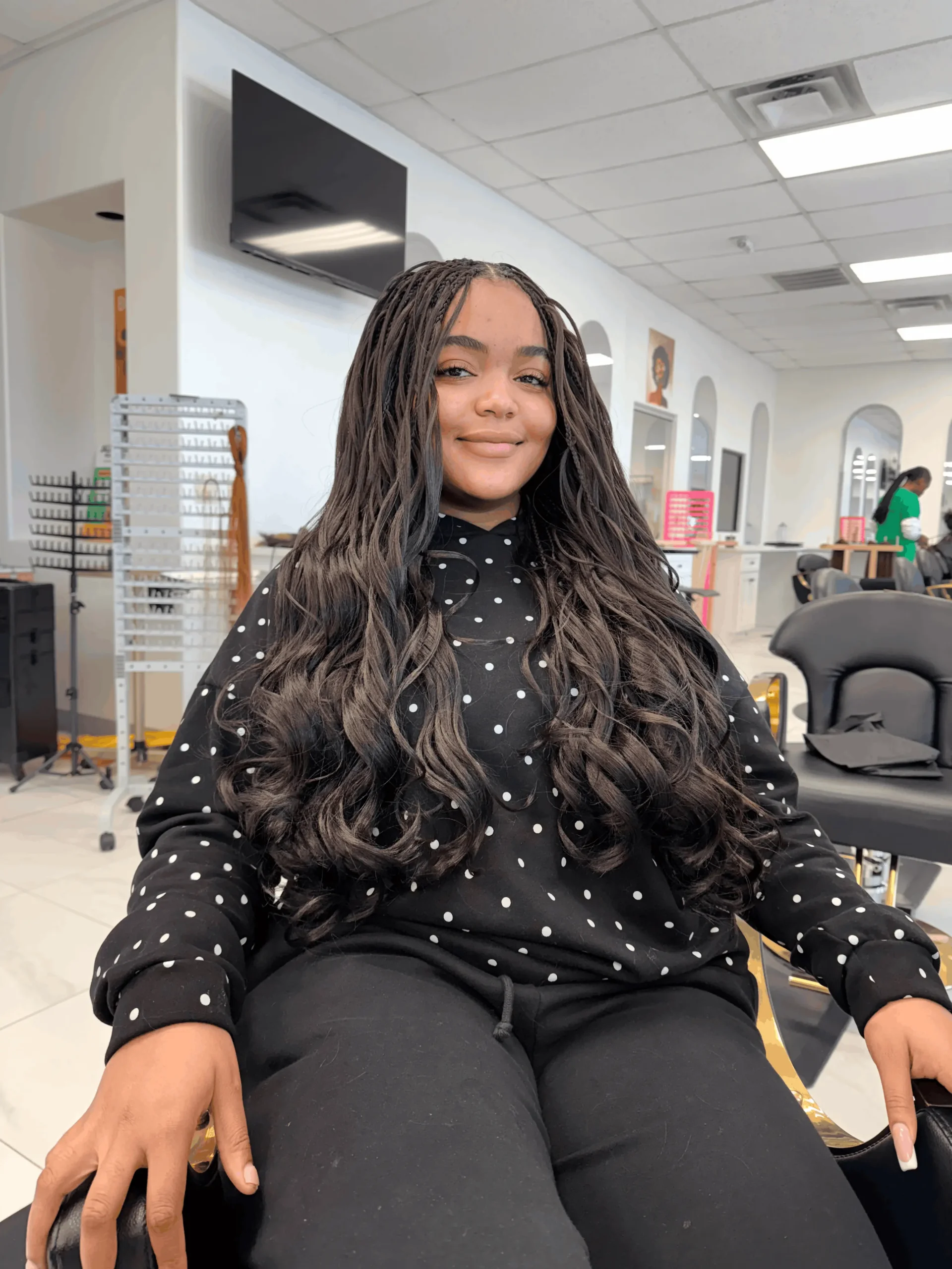 Waist-length French curl braids in dark brown, worn loose, in the chair at Jalia Walda Salon in Houston