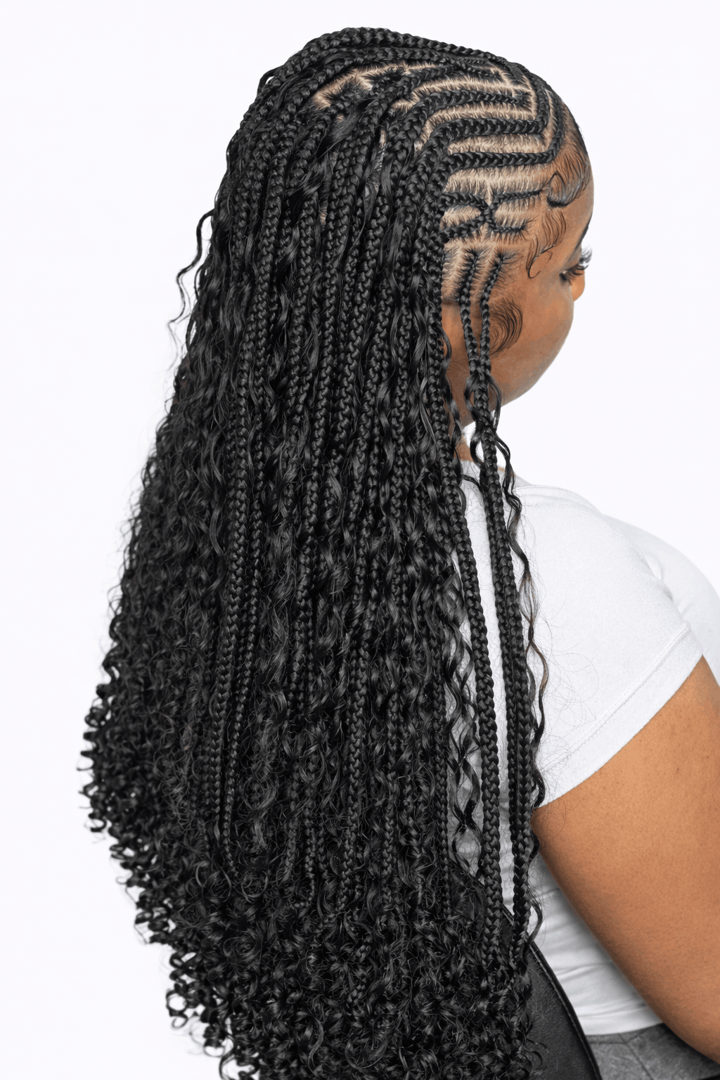 Back view of waist-length Fulani braids with boho curly ends and a side cornrow pattern, Houston TX